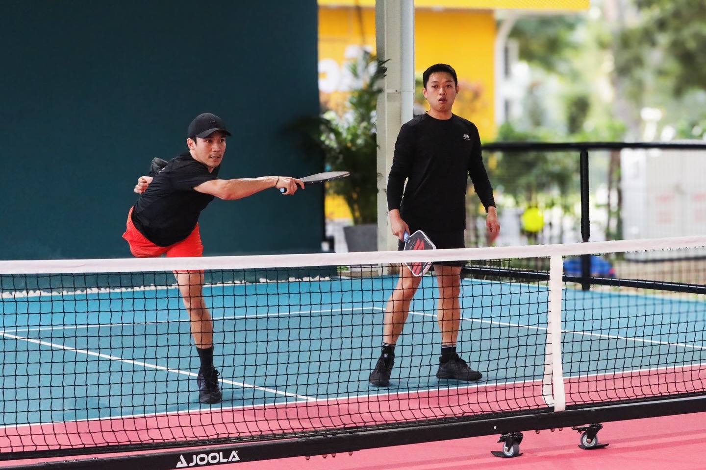 Pickleball players training together on court